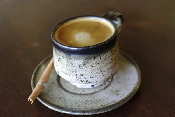 Caffè su tazza di argilla con stecca di cannella — Foto Stock