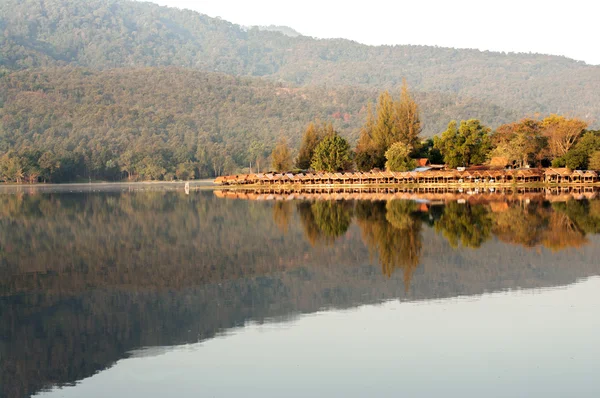 Shops by beautiful lake, water reservoir by natural mountain — Stock Photo, Image