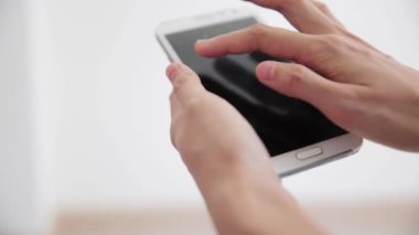 Beyaz arka plan üzerinde akıllı telefon kullanarak ele