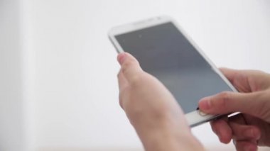 Beyaz arka plan üzerinde akıllı telefon kullanarak ele