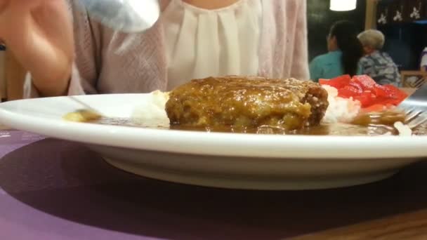 กินอาหารญี่ปุ่น แฮมเบอร์เกอร์กับแกงกะหรี่บนข้าว ช้อนและส้อมเปิดเนื้อ — วีดีโอสต็อก