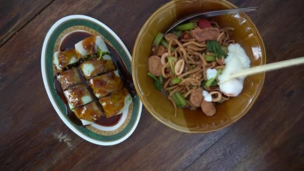 箸と手をシェアするトップビューの動きプーケットの地元の食べ物を共有する炒めホッキン麺とシーフードロール — ストック動画