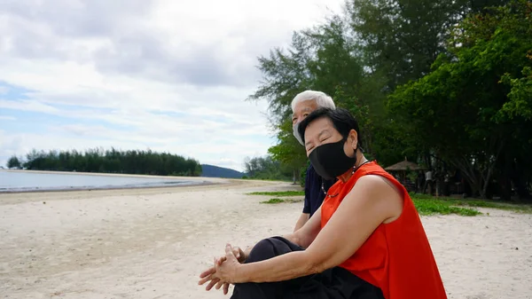 Asian Senior Couple Mask Relax Sitting Beach Log White Sand — Stock Photo, Image