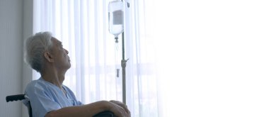 Asyalı yaşlı bir adam tekerlekli sandalyede yalnız ve umutsuz bir şekilde sakat kalıyor. Hayattaki finansal sorunları düşünüyorum.