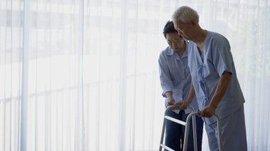 Yaşlı çift hastane afişlerinde Walker 'la rehabilitasyon terapisi yapıyor.