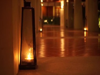 Lamba ve mum, iç koridorda romantik bir mekan dekorasyonu için sıcak ve rahat bir ışık verir.