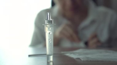 Asyalı kadın test etmeden önce ATK antijen test kiti tüpünü örnek temizleme işlemi ile kapat