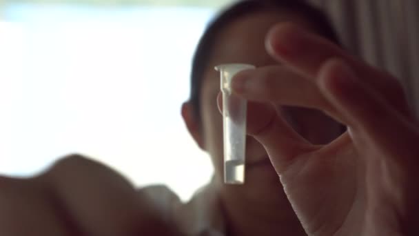 亚洲妇女做Covid Atk抗原鼻腔自我检测试剂盒 将鼻腔中的液体与管子中的抗氧化剂混合 — 图库视频影像