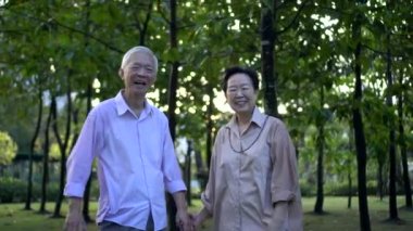Asya kıdemli çifti sabah parkında gülüyor.