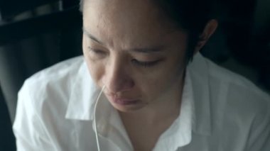 Asyalı bir kadın burnundan ATK burun takasını covid-19 ile kendi test eder.
