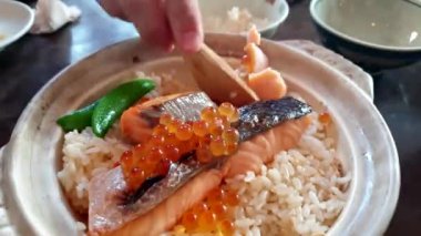 Japon yemeği stili kil çömlek somon pilavı ve ikura yumurtası.