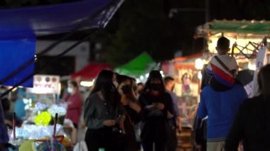 Mukdahan, Tayland 9 Kasım 2021; Yeni normal yaşam tarzı yerel Taylandlı gece pazarında maske takıyor