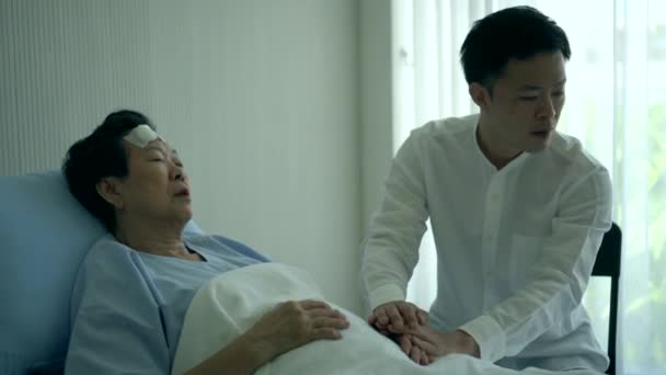 亚洲家庭的儿子在医院病床等医生来检查母亲的病情 — 图库视频影像