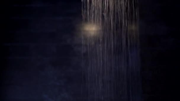 暗い室内バスルームに雨のシャワーの水が流れ落ちる光 — ストック動画