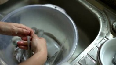 Mutfak lavabosunda tuzlu su ile el yıkama ve yemek hazırlama.