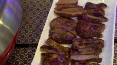 Thai style spicy chili hot pot with sliced meats in neon night light restaurant