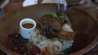 Bali Füzyon Yemekleri Endonezya Geleneksel baharatlar Pirinç üzerinde sığır kaburga çatal ve kaşıkla yemek