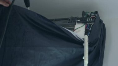Profesyonel klima, yıllık AC bobinindeki kiri temizlemek için yüksek su basınçlı silahı temizliyor.
