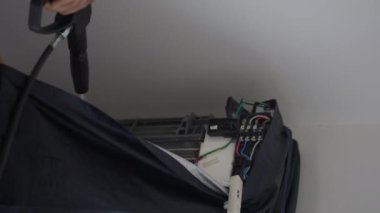 Profesyonel klima, yıllık AC bobinindeki kiri temizlemek için yüksek su basınçlı silahı temizliyor.
