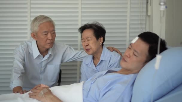 アジアの高齢者の親は大人の息子の健康状態を心配悲しい 事故で負傷した嘘をつく男 — ストック動画