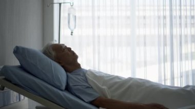 Asyalı son sınıf öğrencisi hastanede tek başına yatıyor. Üzücü depresyon ifadesi sağlıksız hastalık durumu.