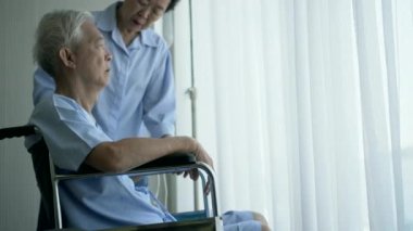 Tekerlekli sandalyedeki Asya 'lı yaşlı adam ve karısı, üzgün ve endişeli olun.