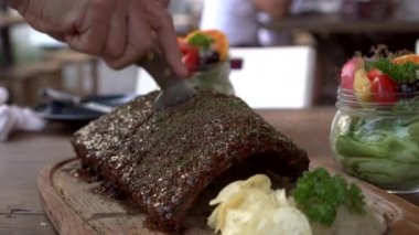 Domuz pirzolası soslu ve baharatlı Amerikan usulü ızgara soslu eller.