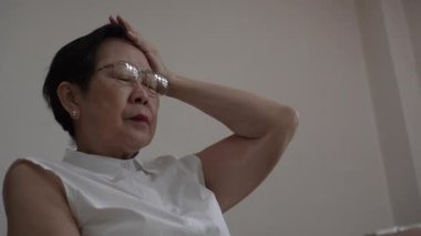 Asian senior woman stress over scam phone call worry need help