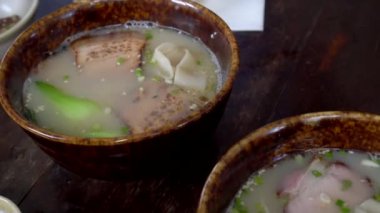 Çin usulü pirinç çorbası, çorba, chashu bbq domuz eti dilimi ve kurutulmuş wonton acı biber sosu.