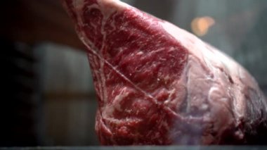Wagyu black Angus tomahawk beef rack dry aged in chilled fridge luxury restaurant