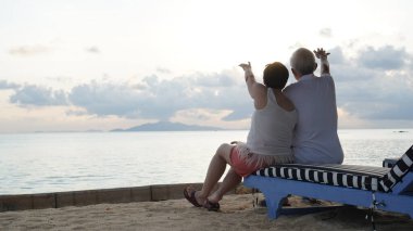 Asyalı yaşlı çift rahatlayın tropikal deniz kenarı tatil tatilinde iyi eğlenceler.