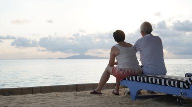 Asyalı yaşlı çift rahatlayın tropikal deniz kenarı tatil tatilinde iyi eğlenceler.