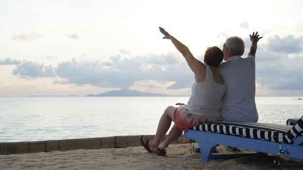 Asian senior elder couple relax enjoy have fun on tropical seaside morning vacation retirement trip together