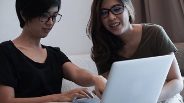 İki girişimci Asyalı kadın gözlüğü laptopla her yerden çalışıyor.