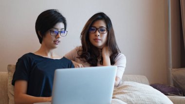 İki girişimci Asyalı kadın gözlüğü laptopla her yerden çalışıyor.
