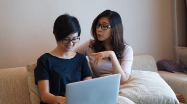 İki girişimci Asyalı kadın gözlüğü laptopla her yerden çalışıyor.