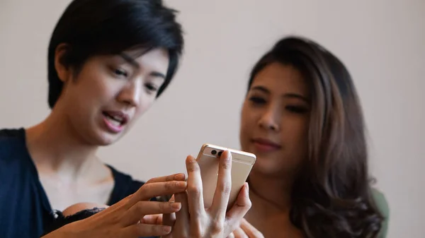 Duas Meninas Asiáticas Compartilhando Compras Line Através Smartphones Discutindo Juntos — Fotografia de Stock