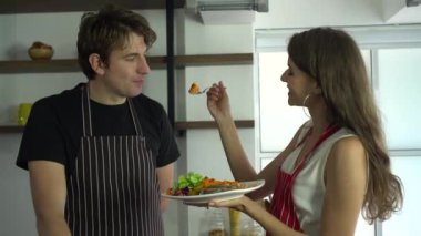 Caucasian couple cooking together happy love feeding kitchen fun time together