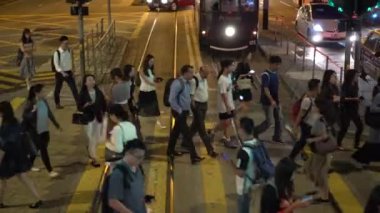 Hong Kong, 23 Ekim 2019: İnsanlar salgın başlamadan önce tramvay hattı üzerinden kalabalık bir şekilde karşıya geçiyor