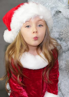 Kırmızı ile Noel ağacı Noel Baba gibi giyinmiş kız