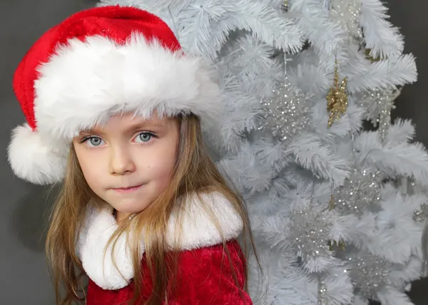 Flickan i rött klädd som jultomte med julgran — Stockfoto