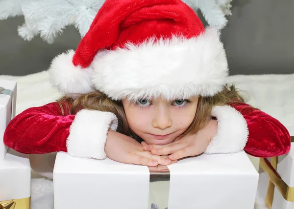 Flickan i rött klädd som jultomte med julgran — Stockfoto