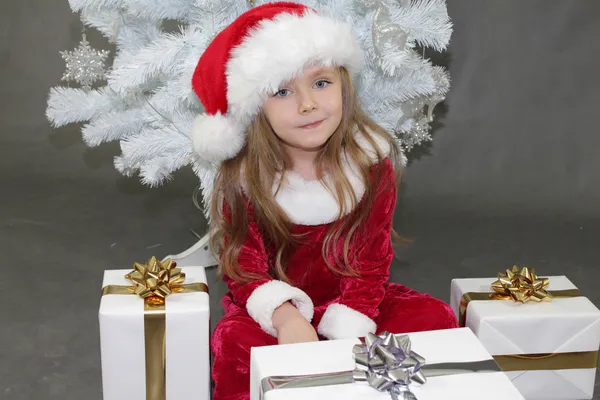 Chica de rojo vestida de Santa Claus con árbol de Navidad —  Fotos de Stock