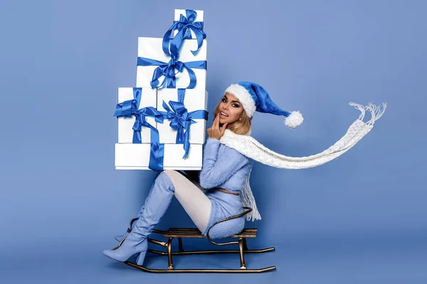 全长体形侧视图迷人的快乐女孩精灵圣诞老人助手骑雪橇送礼品盒便宜货孤立明亮鲜亮的光泽充满活力的蓝色背景 — 图库照片