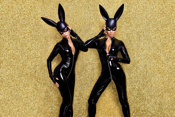 性感的金发女人穿着乳胶服装 戴着黑色兔子面具 背景金光闪闪 复活节兔子的概念 Latex内衣 淘气的女孩 万圣节服装 — 图库照片