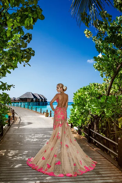 高級ファッションだ エレガントなファッションモデルは屋外をポーズしています モルディブのビーチでロングドレスを着たスタイリッシュな女性モデル 優雅さ モルディブの風景の中で素晴らしいドレスを着た上品な女性 クチュール ヴォーグ — ストック写真