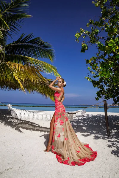 高級ファッションだ エレガントなファッションモデルは屋外をポーズしています モルディブのビーチでロングドレスを着たスタイリッシュな女性モデル 優雅さ モルディブの風景の中で素晴らしいドレスを着た上品な女性 クチュール ヴォーグ — ストック写真