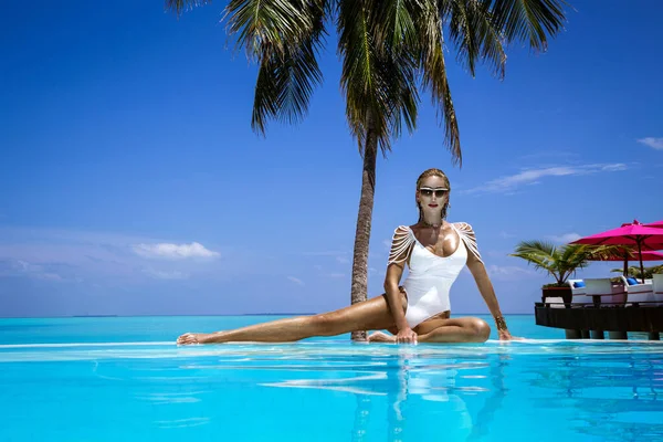 在热带马尔代夫岛上 穿着白色泳衣的优雅的晒黑的女人在游泳池里 美丽的比基尼身材女孩在游泳池与地平线上的视野 在美丽的印度洋景观的水池边的性感模特 马尔代夫的景观 — 图库照片