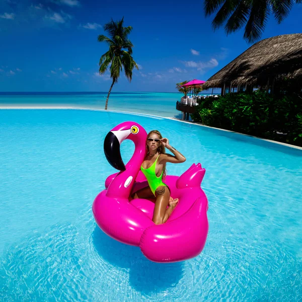 在游泳池里的粉色火烈鸟上 美丽性感的晒黑的女人 马尔代夫岛上穿着泳衣的年轻貌美的姑娘 马尔代夫豪华度假胜地完美的比基尼模特 奢侈的旅行 夏天的时间 — 图库照片