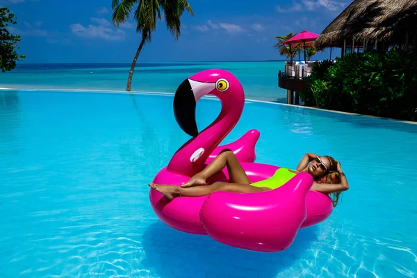 在游泳池里的粉色火烈鸟上 美丽性感的晒黑的女人 马尔代夫岛上穿着泳衣的年轻貌美的姑娘 马尔代夫豪华度假胜地完美的比基尼模特 奢侈的旅行 夏天的时间 — 图库照片